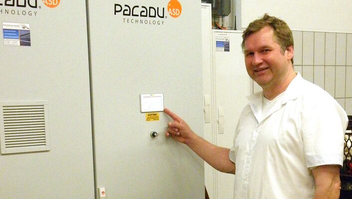 am Pacadu-Stromspeicherschrank Ein Mann zeigt auf einen Metallschrank