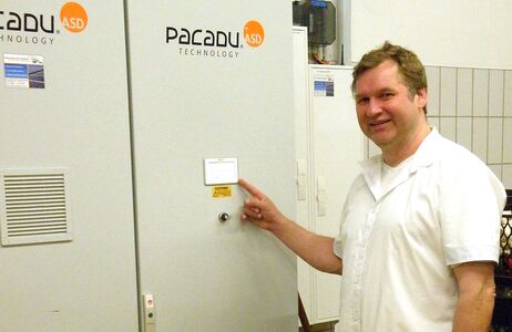 Ein Mann zeigt auf einen Metallschrank