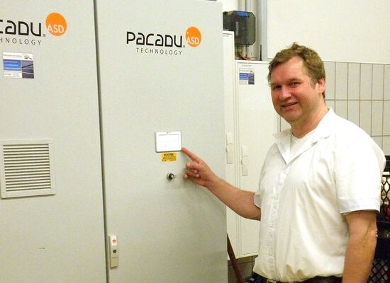Ein Mann zeigt auf einen Metallschrank